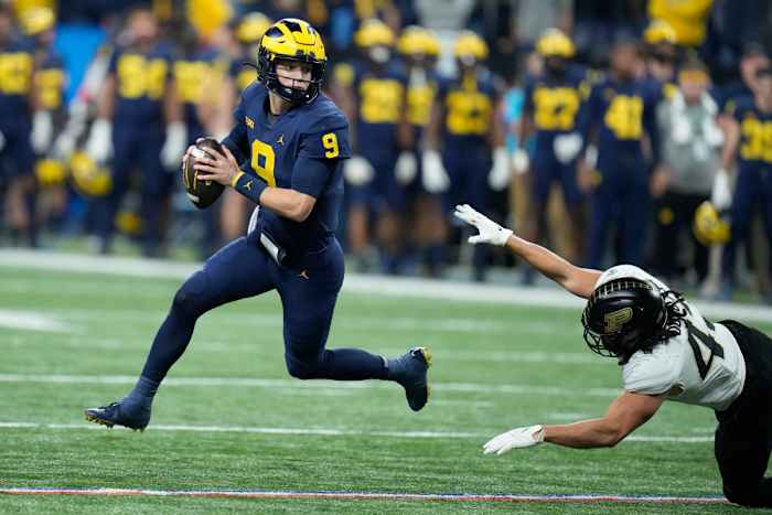 Michigan quarterback J.J. McCarthy (9) scrambles as Purdue linebacker Kieren Douglas defends during the first half of the Big Ten championship NCAA college football game, Saturday, Dec. 3, 2022, in Indianapolis.